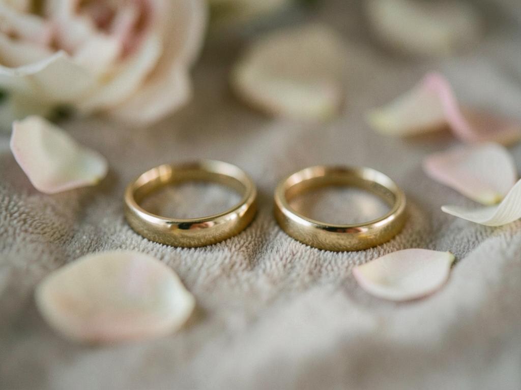 Two gold wedding rings with soft flower petals